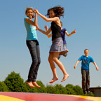 Kinder springen auf einem großen bunten Hüpfberg.