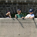 Drie jongens op de eretribune van het amfiheater. Foto kan in het nieuwe venster worden vergroot.