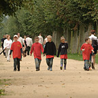 Besucherinnen und Besucher streifen auf den breiten Alleen durch den Park.