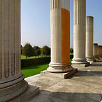 Blick durch einige Säulen in den grünen Park.