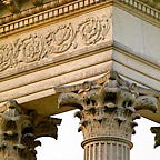 Detailopname van het Corinthisch kapiteel (het bovenste gedeelte van de zuilen) en het versierde balkwerk.