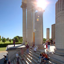 Podium, Treppe und einige Säulen des Hafentempels werden von Besucherinnen und Besuchern besichtigt.
