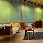 Gereconstrueerde Romeinse meubels, een tapijt en een muurschildering in één van de woonruimtes.
