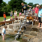 Kinderen spelen op de waterspeelplaats. 