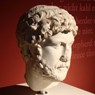 Marmorbüste Kaiser Hadrians auf rotem Grund.