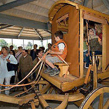 Kinderen op een houten romeinse wagen in het themapaviljoen "Reizen & verkeer"