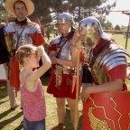 Ein kleines Mädchen unterhält sich mit einem Mann in römischer Uniform.