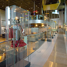 Blik op een lange helling in het RömerMuseum. Op de voorgrond een legionairsuitrusting.