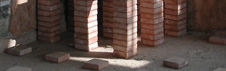 Gereconstrueerde bakstenen pijlers die de loopvloer in één van de zweetbaden droegen.