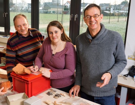 Carsten Bendix, Elisabeth Krieger und Bernd Liesen an einem Tisch mit archäologischen Fundstücken