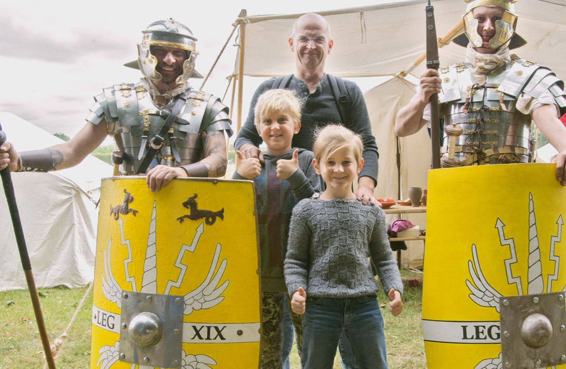 Vader met twee zonen, geflankeerd door twee lachende legionairs 