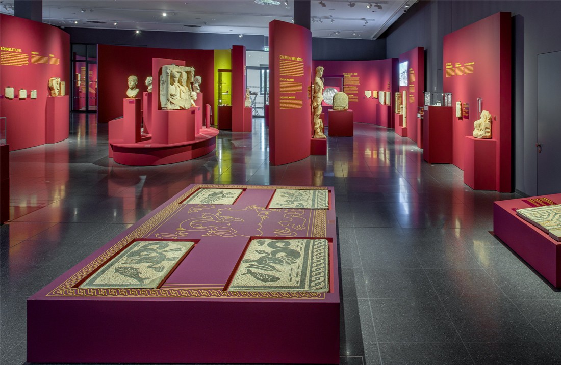 Blick in den Ausstellungsraum, große Tafel mit vier Mosaikfragmenten im Vordergrund