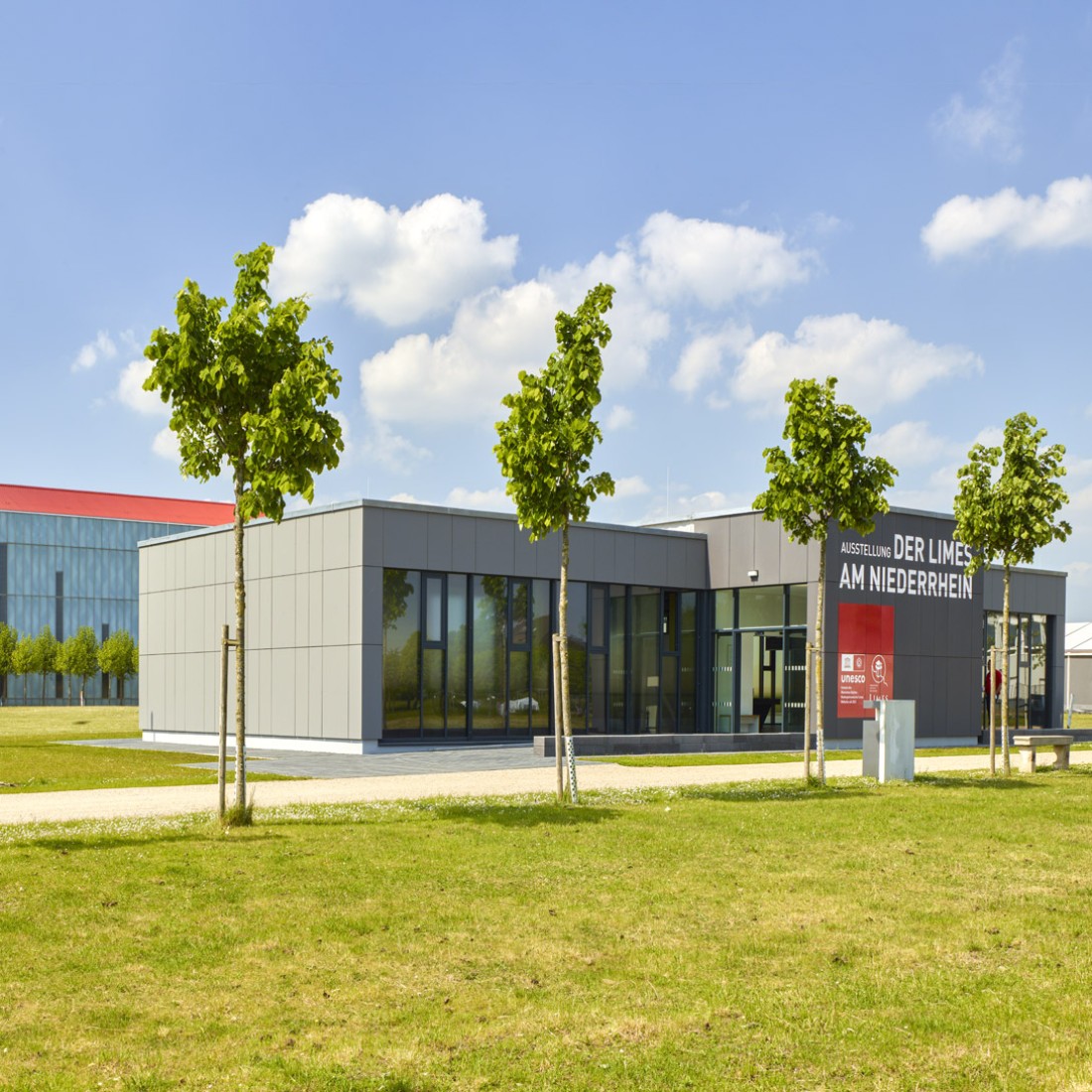 View on the Limes Pavilion with young trees in the foreground and the LVR Römermuseum in the background